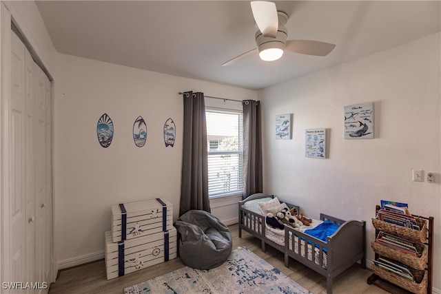 bedroom featuring ceiling fan, light wood-type flooring, and a closet