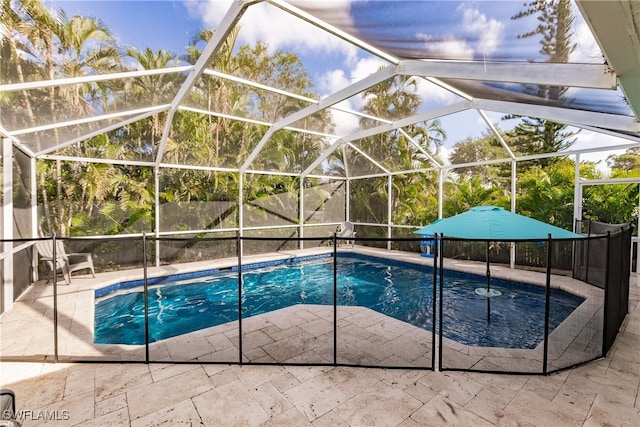 view of swimming pool featuring a lanai and a patio area