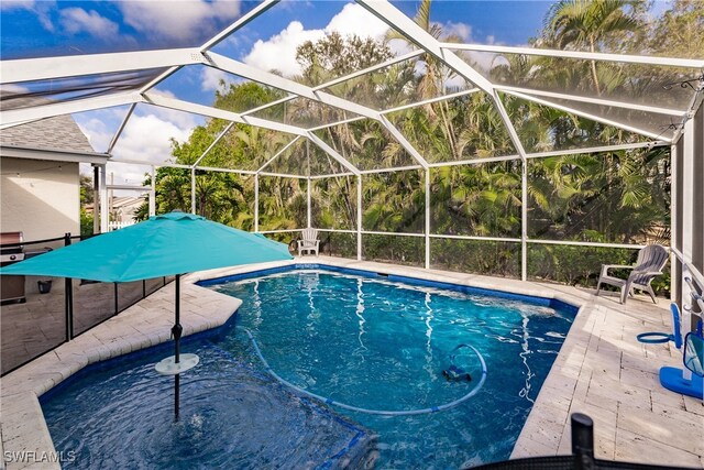 view of swimming pool with a patio and a lanai