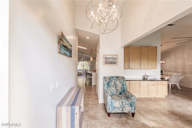 interior space with ceiling fan with notable chandelier and high vaulted ceiling