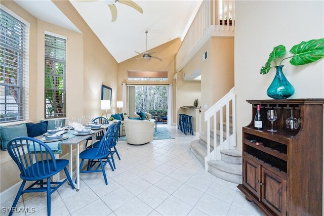 tiled dining room with high vaulted ceiling and ceiling fan