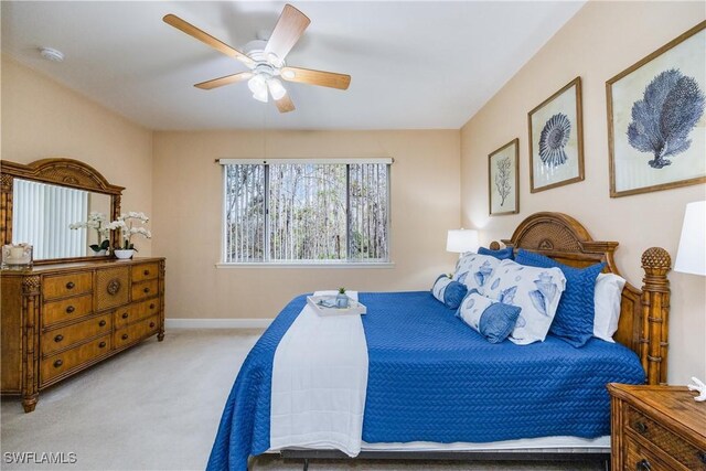 bedroom featuring ceiling fan, baseboards, and light colored carpet