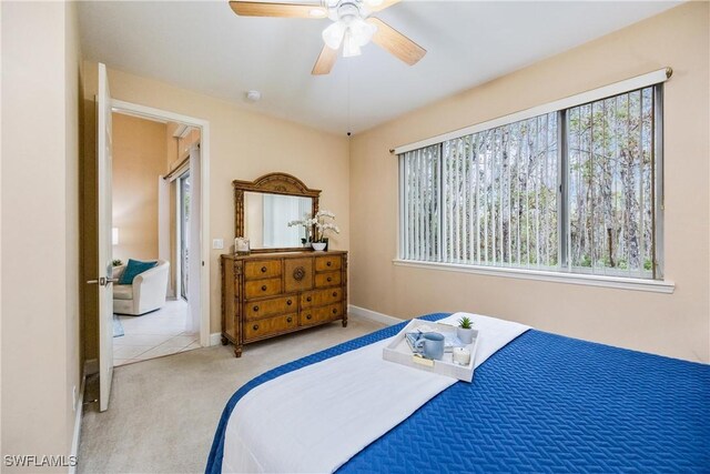 bedroom featuring a ceiling fan, carpet, multiple windows, and baseboards