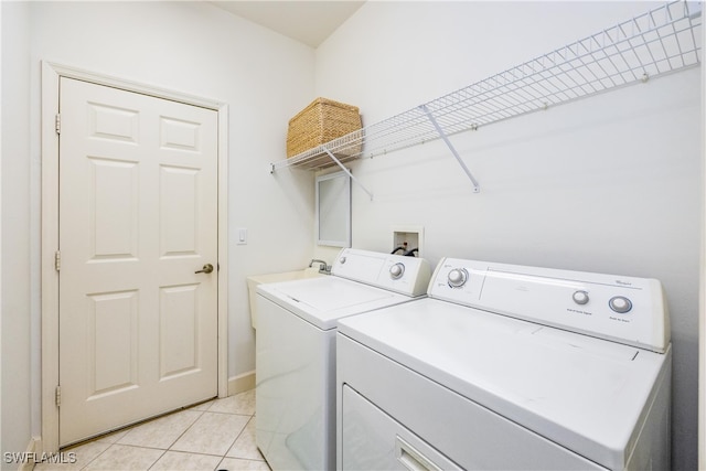 laundry area featuring light tile patterned floors, laundry area, baseboards, and washer and dryer