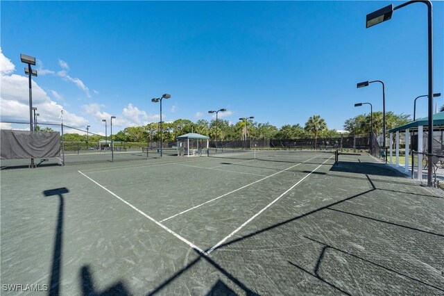 view of tennis court featuring fence