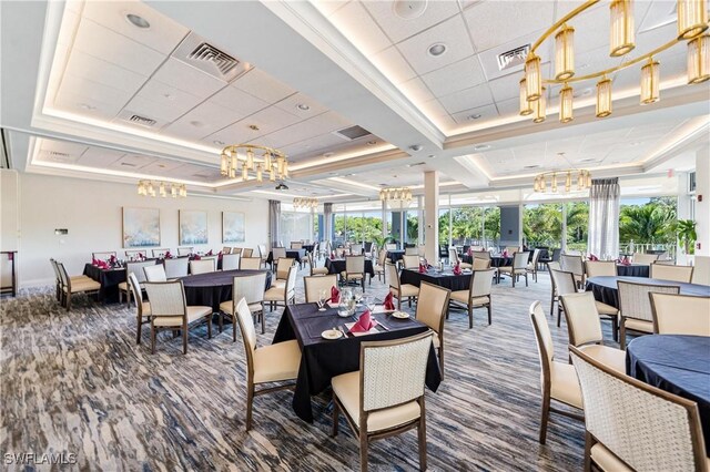 dining room with visible vents, a raised ceiling, and carpet flooring