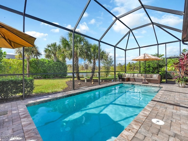 view of pool with outdoor lounge area, a patio area, and glass enclosure