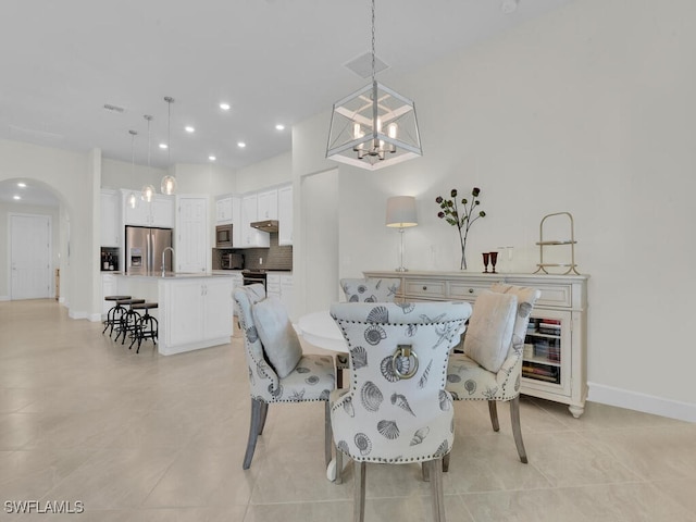 tiled dining room with an inviting chandelier