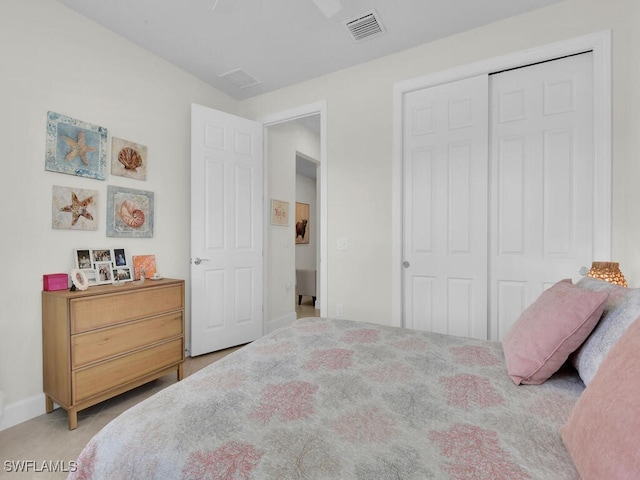 bedroom with ceiling fan, a closet, and light colored carpet