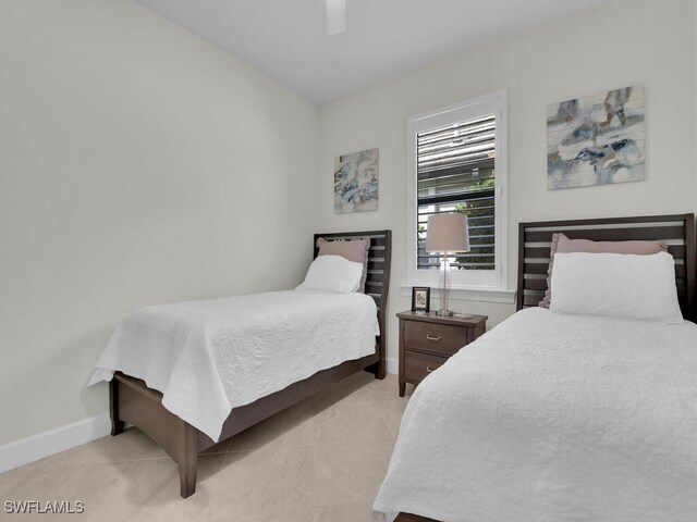 tiled bedroom featuring ceiling fan