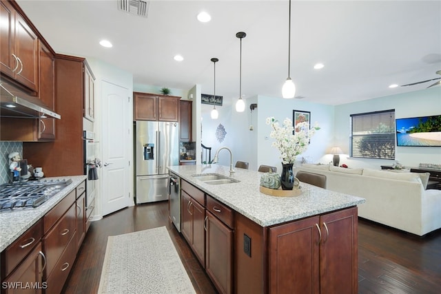 kitchen featuring a kitchen island with sink, appliances with stainless steel finishes, sink, and dark hardwood / wood-style flooring