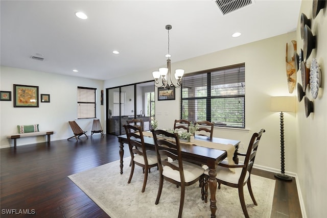 dining area with dark hardwood / wood-style floors and a chandelier