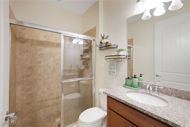 bathroom with vanity, toilet, and a shower with door