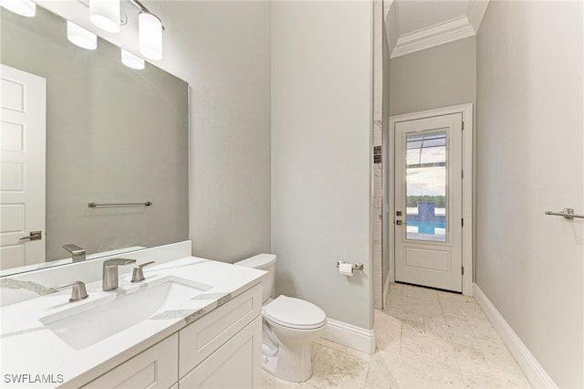 bathroom featuring toilet, vanity, and ornamental molding