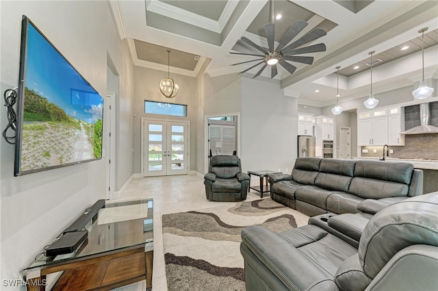 tiled living room featuring beamed ceiling, ceiling fan with notable chandelier, crown molding, coffered ceiling, and french doors