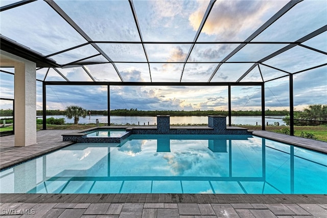 view of swimming pool featuring a water view, glass enclosure, an in ground hot tub, and a patio area