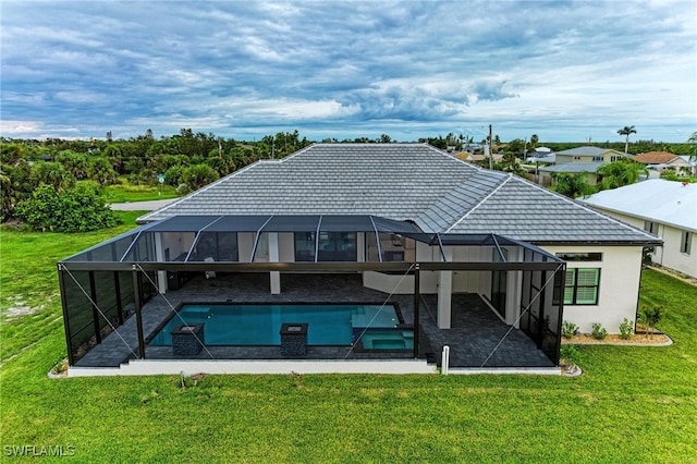 back of property featuring a yard, glass enclosure, and a patio area