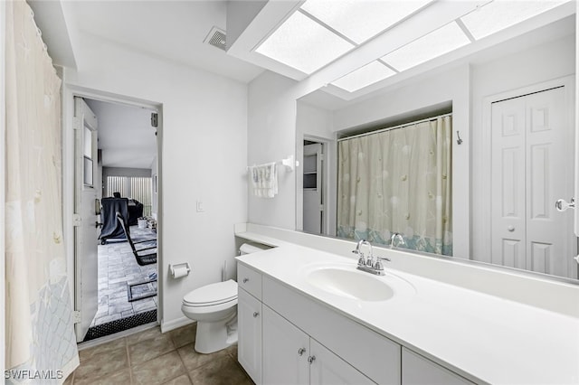 bathroom featuring tile patterned flooring, vanity, and toilet