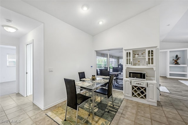 tiled dining space with lofted ceiling