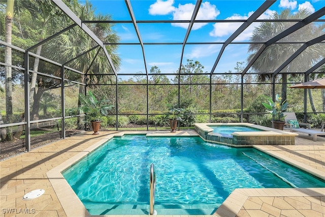 view of pool with a patio, glass enclosure, and an in ground hot tub