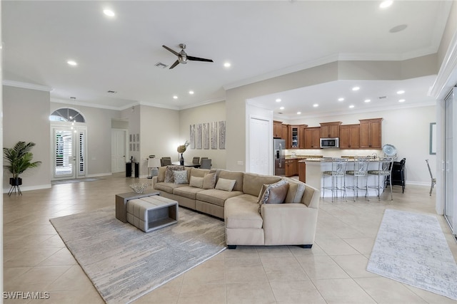 living room featuring ceiling fan, light tile patterned floors, and crown molding