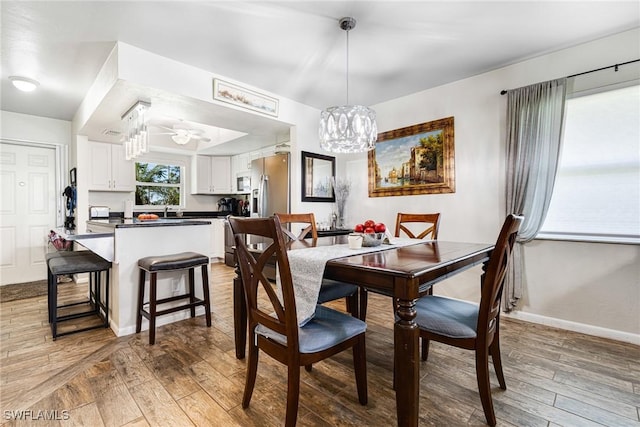 dining area featuring an inviting chandelier and light hardwood / wood-style floors