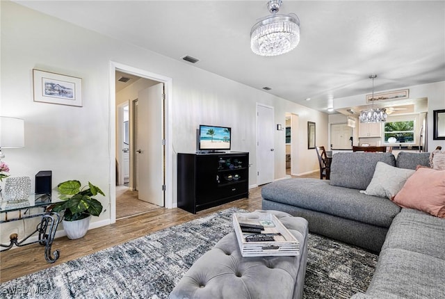 living room with wood-type flooring and a notable chandelier