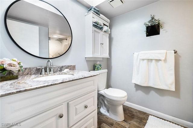 bathroom with wood-type flooring, toilet, and vanity