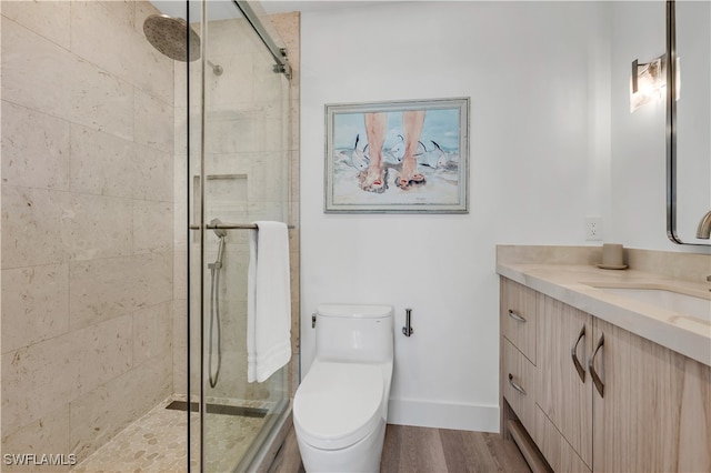 bathroom featuring hardwood / wood-style flooring, vanity, walk in shower, and toilet