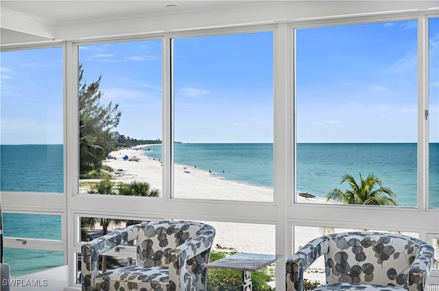 sunroom with a water view, plenty of natural light, and a view of the beach