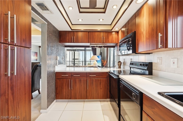 kitchen with black appliances, decorative backsplash, light tile patterned flooring, and a raised ceiling