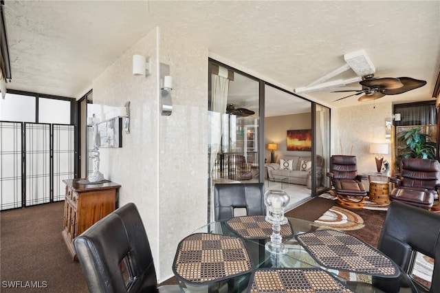 dining area with ceiling fan, a textured ceiling, and dark colored carpet