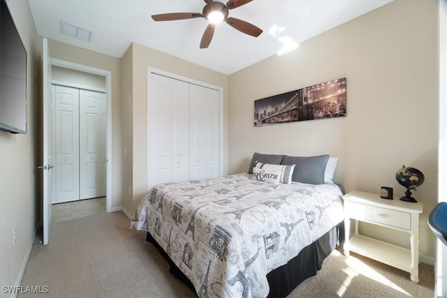 carpeted bedroom featuring baseboards, visible vents, a closet, and ceiling fan