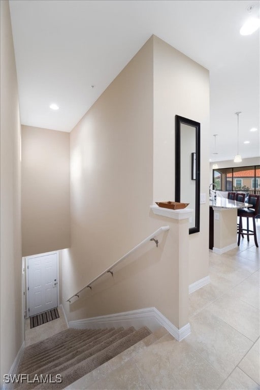 staircase with tile patterned floors, recessed lighting, and baseboards