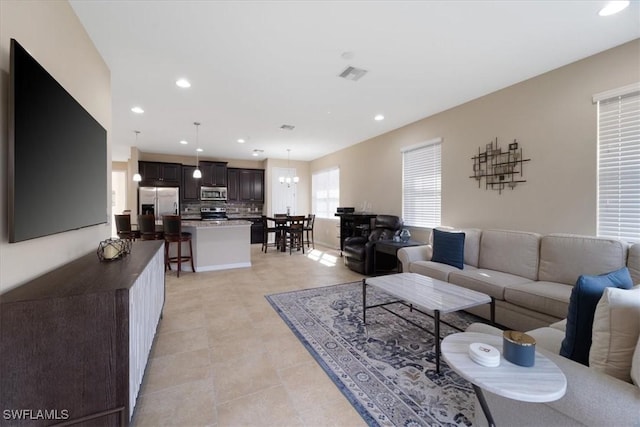 living area featuring recessed lighting and visible vents