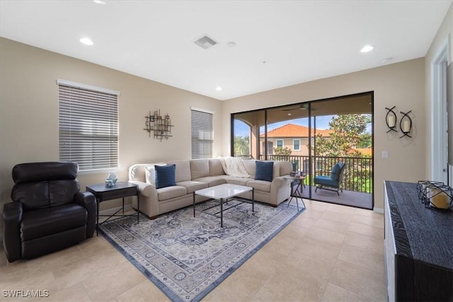 living area with light tile patterned floors, recessed lighting, visible vents, and baseboards