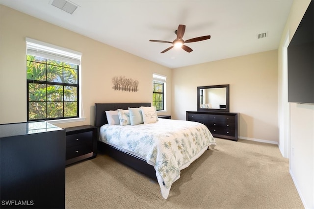 bedroom with light colored carpet, baseboards, visible vents, and a ceiling fan