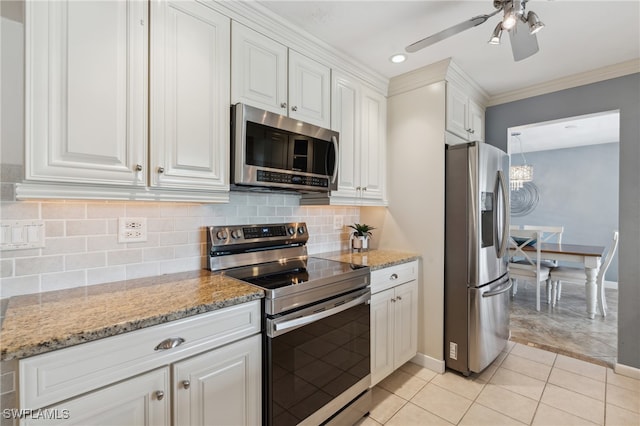 kitchen featuring white cabinetry, stainless steel appliances, tasteful backsplash, light stone counters, and crown molding