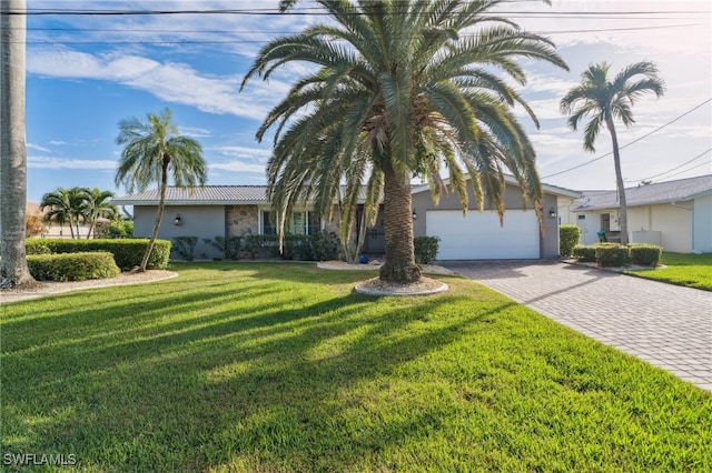 ranch-style house featuring a garage and a front lawn