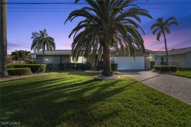 single story home featuring a yard and a garage