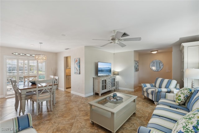 living room featuring ceiling fan with notable chandelier and light tile patterned flooring