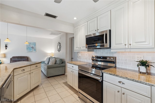 kitchen with backsplash, light stone counters, stainless steel appliances, pendant lighting, and white cabinets