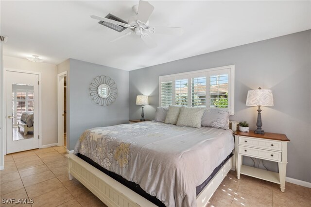 bedroom with ceiling fan, light tile patterned floors, and multiple windows