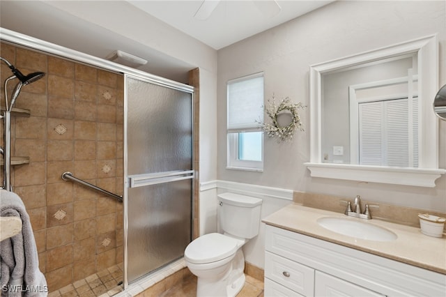 bathroom featuring tile patterned floors, vanity, toilet, and a shower with shower door