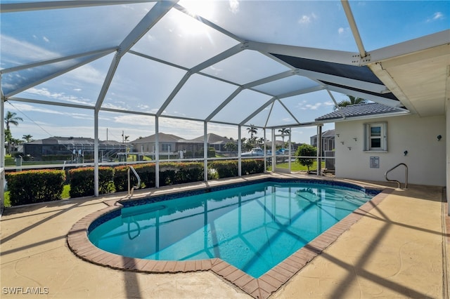 view of pool featuring glass enclosure and a patio area