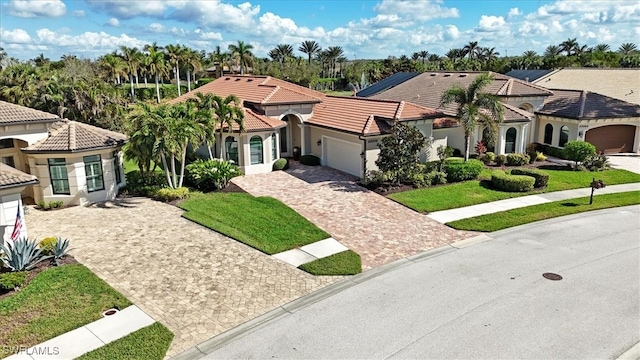 mediterranean / spanish-style house with a front lawn and a garage