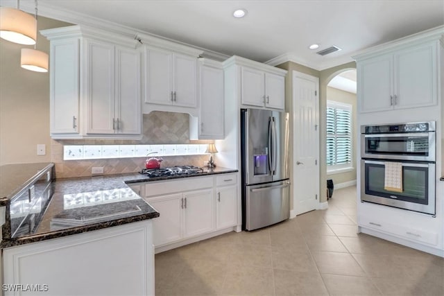 kitchen featuring decorative backsplash, pendant lighting, white cabinets, and stainless steel appliances