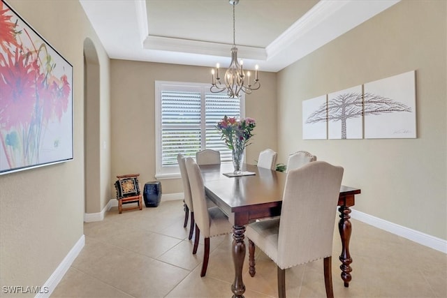 dining space featuring a tray ceiling, crown molding, light tile patterned floors, and an inviting chandelier