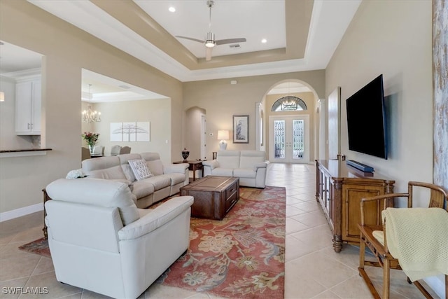 living room featuring a tray ceiling and light tile patterned flooring