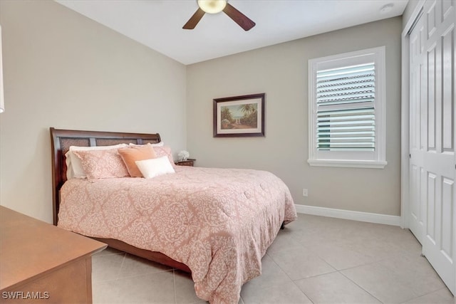 tiled bedroom featuring ceiling fan and a closet